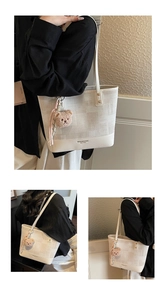 Detail showing beige leather and gray plaid jacquard contrast on tote bag with bear charm