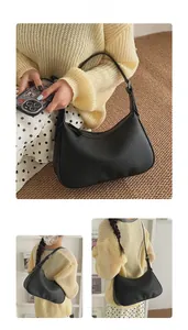Detail shot of black litchi pattern leather crescent bag with smooth zipper closure