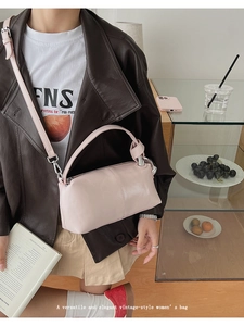 Detail of a light pink barrel handbag with a unique knotted handle and adjustable strap