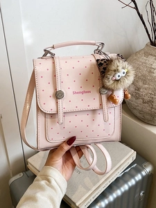Pink polka dot mini backpack and crossbody bag with a cute plush cat charm decoration