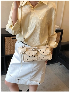 Polka dot crossbody bag with double front pockets and a cute heart-shaped charm detail