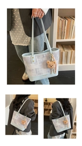Detail of light blue bucket bag with geometric canvas texture and cute bear charm