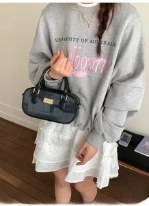 Gros plan d'un sac Boston en jacquard noir porté par un mannequin en tenue de style preppy