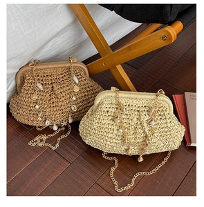 Detail of woven straw cloud bags with seashell and pearl charms on metal chain straps