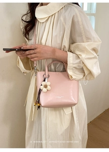 Borsa a mano rosa in ecopelle con ciondolo floreale in maglia in un contesto lifestyle