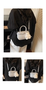 Detail of light grey mini crossbody bag with leather strap and cute plush animal charm