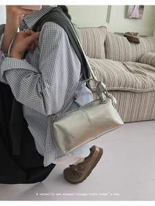 Detail view of silver vintage-style handbag featuring a unique knotted shoulder strap