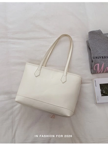 Minimalist white tote bag showing spacious interior on a neutral fabric background