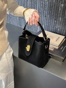 Chic black suede bucket handbag with gold twist lock and top handle for women