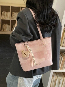 Grand sac cabas rose avec imprimé pixel et breloque ours porté par un mannequin