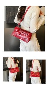 Detail of red polka dot shoulder bag featuring heart charm and functional buckle pockets