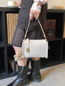 Classic retro off-white leather handbag with gold hardware and teddy bear charm accessory