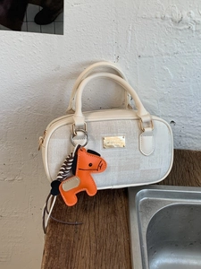 Sac Boston minimaliste en beige et cuir avec un charmant pendentif de cheval orange
