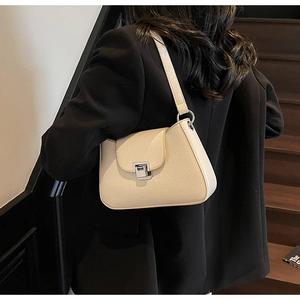 Détail du sac sous le bras en cuir PU crème avec plis vintage et fermoir métallique