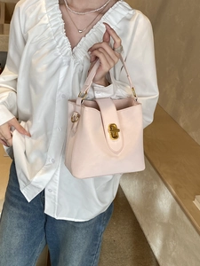 Chic pale pink bucket bag with gold hardware and short handle for elegant office style