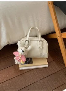 Detail of cream Boston bag with leather straps and cute white rabbit plush charm