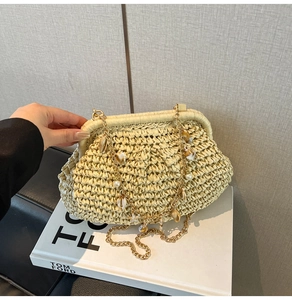 Close-up of woven straw beach bag featuring seashell and pearl gold chain detail