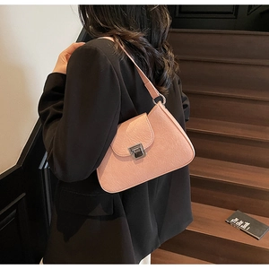 Sac sous les aisselles rose plissé avec boucle argentée porté par un mannequin en blazer