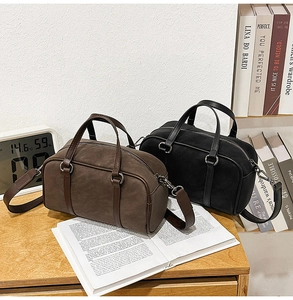 Macro view of vintage brown and black matte suede Boston bags on a wooden table