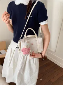 Nahaufnahme der weißen Boston Bag mit rosa Katzendrucken und süßem Plüschbären-Anhänger