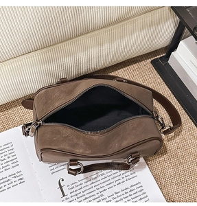 Macro view of the spacious black interior and silver metal zipper of the brown Boston bag