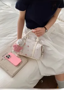 Detail der weißen Boston-Tasche mit süßen Bären-Prints und Plüsch-Anhänger am Griff