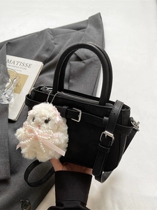 Elegante borsa tote in pelle PU nera con ciondolo a coniglio in peluche su sfondo minimalista