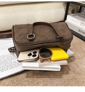 Detail showing the large storage capacity of the brown suede Boston bag with daily items