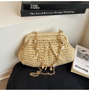 Detail of woven straw bag with chunky gold chain, seashell and pearl charms