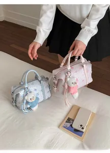 Detail von rosa und blauen Boston-Taschen mit Zeichentrickmotiven und Eisbär-Anhängern