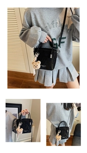 Three-way view of a black pleated bucket bag with plush bear charm and crossbody strap