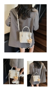 Detail of silver textured bucket bag with plush bear charm and adjustable strap