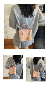 Detailed view of pink mini bucket bag with bear pendant and detachable shoulder strap