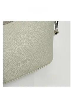 Nahaufnahme der cremefarbenen Leder-Beuteltasche mit NO FILTER Text und Silber-Schnalle