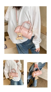 Detailed macro view of pink patent leather pillow bag with plush bear charm and gold zipper