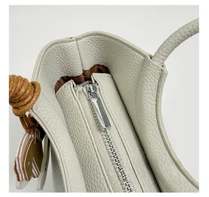Detailansicht der weißen Tasche aus Narbenleder mit Silber-Reißverschluss und Innenfutter