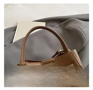 Detailed close-up of brown lychee leather bucket bag with metallic twist lock hardware