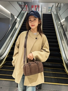 Deep brown matte Boston handbag styled with beige trench coat and blue cap for daily wear