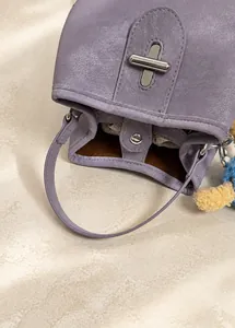 Detail of purple lychee textured bucket bag with wide strap and silver metal twist lock
