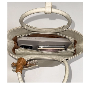 Draufsicht der weißen Leder-Beuteltasche mit Innenfächern und braunem Textilfutter