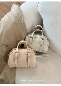 Minimalist beige and cream retro mini Boston handbags shown on a sofa in a lifestyle setting