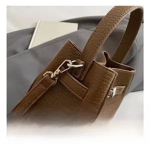 Detailed close-up of premium silver metal hardware and lychee grain leather on bucket bag