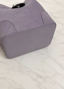 Detail of the reinforced base and stitching on a purple leather bucket handbag