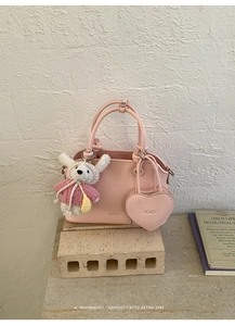 Pink minimalist shell handbag with heart pouch and bunny charm on stone base