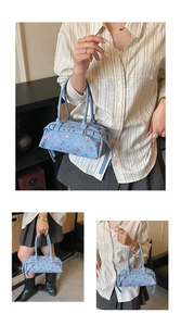 Detail showing vintage denim bowling bag with red rose floral pattern and metal buckles