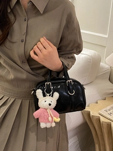 Minimalist black glossy handbag with a cute teddy bear charm and silver metal hardware