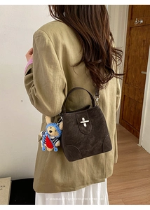 Brown retro bucket bag with suede texture, silver twist lock and cute bear charm detail