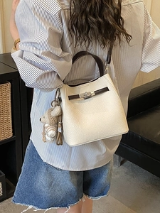 White lychee leather bucket bag with brown handles and cute bear charm for women