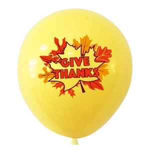 Close-up of a bright yellow Give Thanks balloon with autumn maple leaf patterns