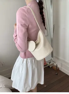 Detail of off-white lychee grain leather shoulder bag with round coin purse attachment